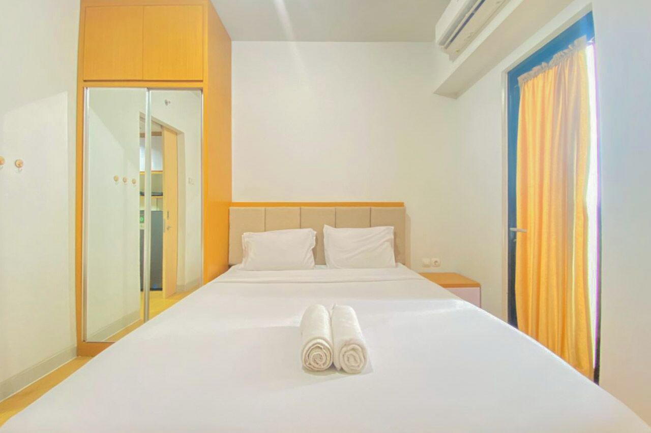 Habitación de hotel con cama, armario, espejo, mesita de noche y ventana con cortinas.