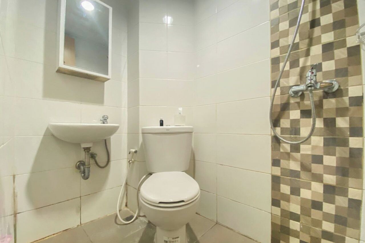 A small bathroom with a toilet, sink, and shower.