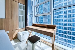 Ein modernes Zimmer mit einem Holztisch, einem weißen Hocker und einem großen Fenster mit Blick auf die Stadt.