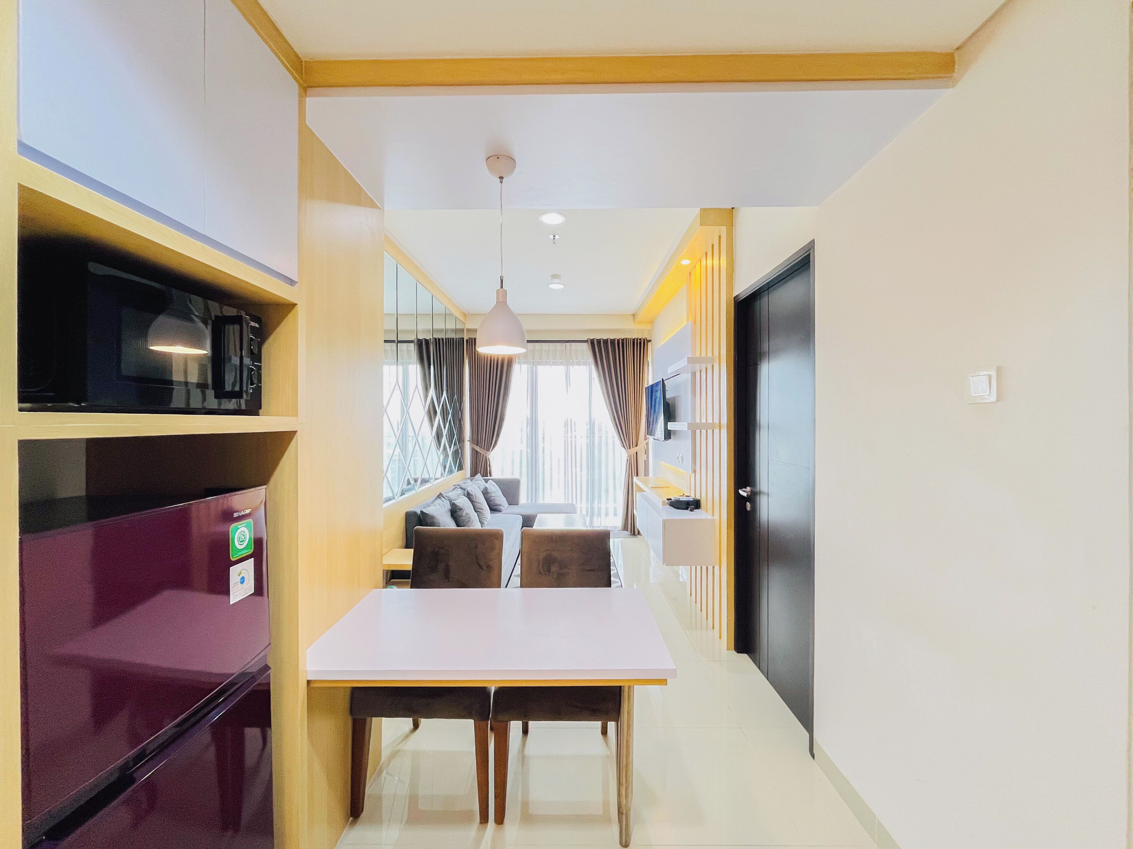 Une chambre d’hôtel moderne dotée d’un coin repas, d’une télévision et d’un four à micro-ondes.