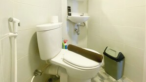 Ein Badezimmer mit Toilette, Waschbecken und Mülleimer.