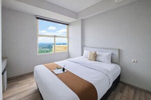 Ein Hotelzimmer mit einem großen Bett, einem Fenster mit Blick, einem Nachttisch und einem Beistelltisch.