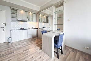 Eine moderne Küche mit Holzschränken, einer integrierten Kochinsel und einem Essbereich mit einem Stuhl.