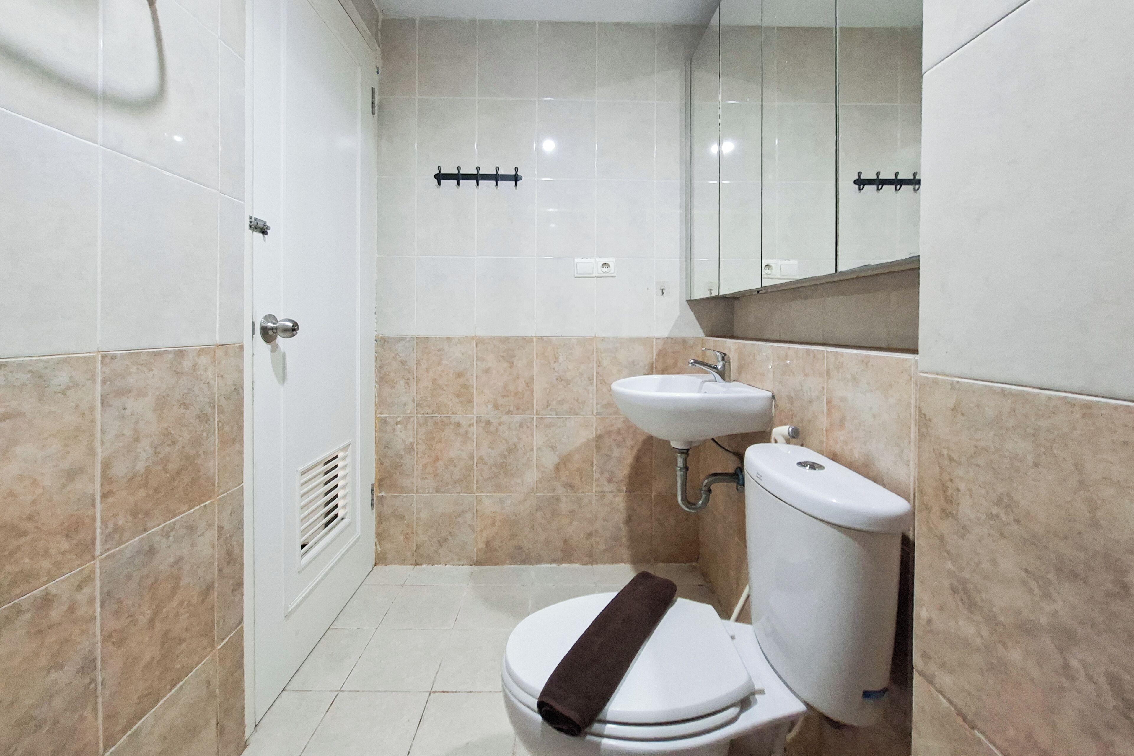 Ein Badezimmer mit Toilette, Waschbecken und Spiegel.