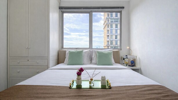 Una camera da letto con un letto, una finestra, un comodino e un armadio.