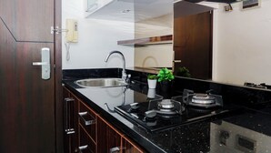 Una cocina moderna con un lavaplatos integrado, grifo de acero inoxidable y estufa a gas.