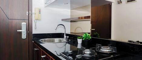 Una cocina moderna con un lavaplatos integrado, grifo de acero inoxidable y estufa a gas.