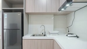 Eine moderne Küche mit einem Edelstahl-Kühlschrank, einer Spüle und einem tragbaren Elektroherd.