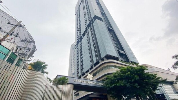 A tall, modern building with a sign reading "Grand Sungkono Lagoon." - 6 Pax Tranquil 3Br With Extra Room At Grand Sungkono Lagoon Apartment (Surabaya)