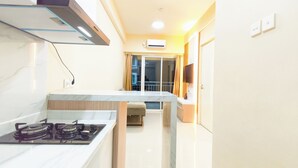A compact kitchen with a gas stove, a built-in oven, and a microwave. - Serene 2Br For 3 Pax At Tanglin Supermall Mansion Apartment (Surabaya)