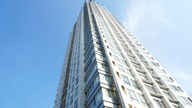 Ein hohes, modernes Hochhaus vor blauem Himmel.