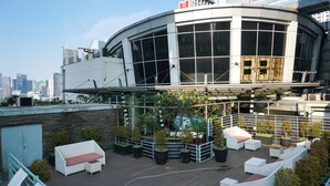 Eine Dachterrasse mit Sitzgelegenheiten im Freien und Topfpflanzen.