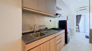 Une cuisine moderne dotée d’un évier en acier inoxydable, de meubles en bois et d’une hotte intégrée.