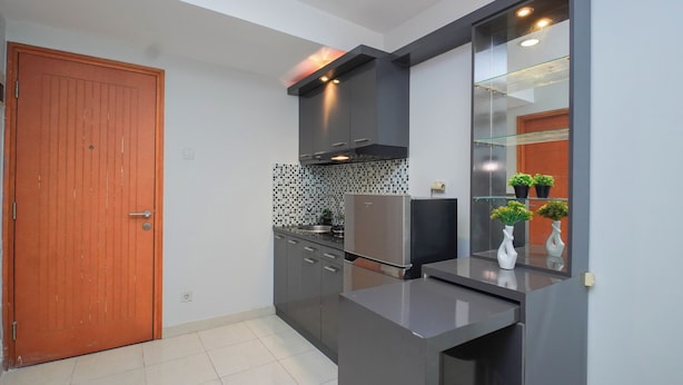 Une cuisine moderne avec une porte en bois, un réfrigérateur, un four à micro-ondes et un pare-feu en verre.
