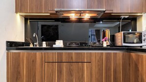 Una cocina moderna con armarios de madera, microondas empotrado y extractor de humos.