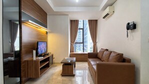Una sala de estar moderna con un televisor de pantalla plana, un sofá de cuero marrón, una mesa de centro de madera y un amplio ventanal con cortinas.