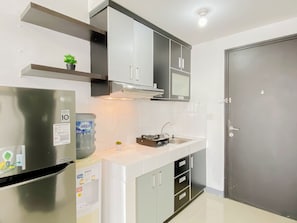 Eine Küche mit Kühlschrank, Wasserspender und Schränken.