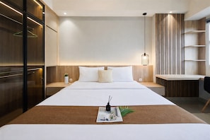 Ein modernes Hotelzimmer mit einem großen Bett, Nachttischen, einem Schreibtisch und einem Kleiderschrank.