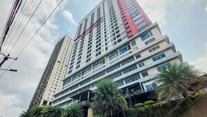 Un edificio alto con varios pisos, una sección roja destacada y un letrero que dice 'YONG'.