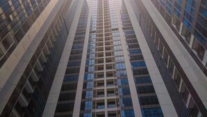 A high-rise building with a modern architectural design, featuring a grid of windows and balconies. - Chic And Roomy 2Br Space At Apartment Casa Grande Residence (Jakarta)