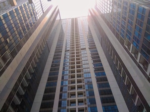 Ein Hochhaus mit moderner Architektur, das ein Raster aus Fenstern und Balkonen zeigt.