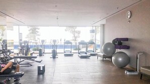 Academia com esteiras, bicicletas ergométricas e bolas de exercício.