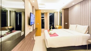 Une chambre d’hôtel moderne équipée d’un grand lit, d’une télévision, d’un bureau et d’un miroir.