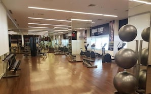 Ein Fitnessstudio mit verschiedenen Trainingsgeräten, darunter Laufbänder und Kraftgeräte.