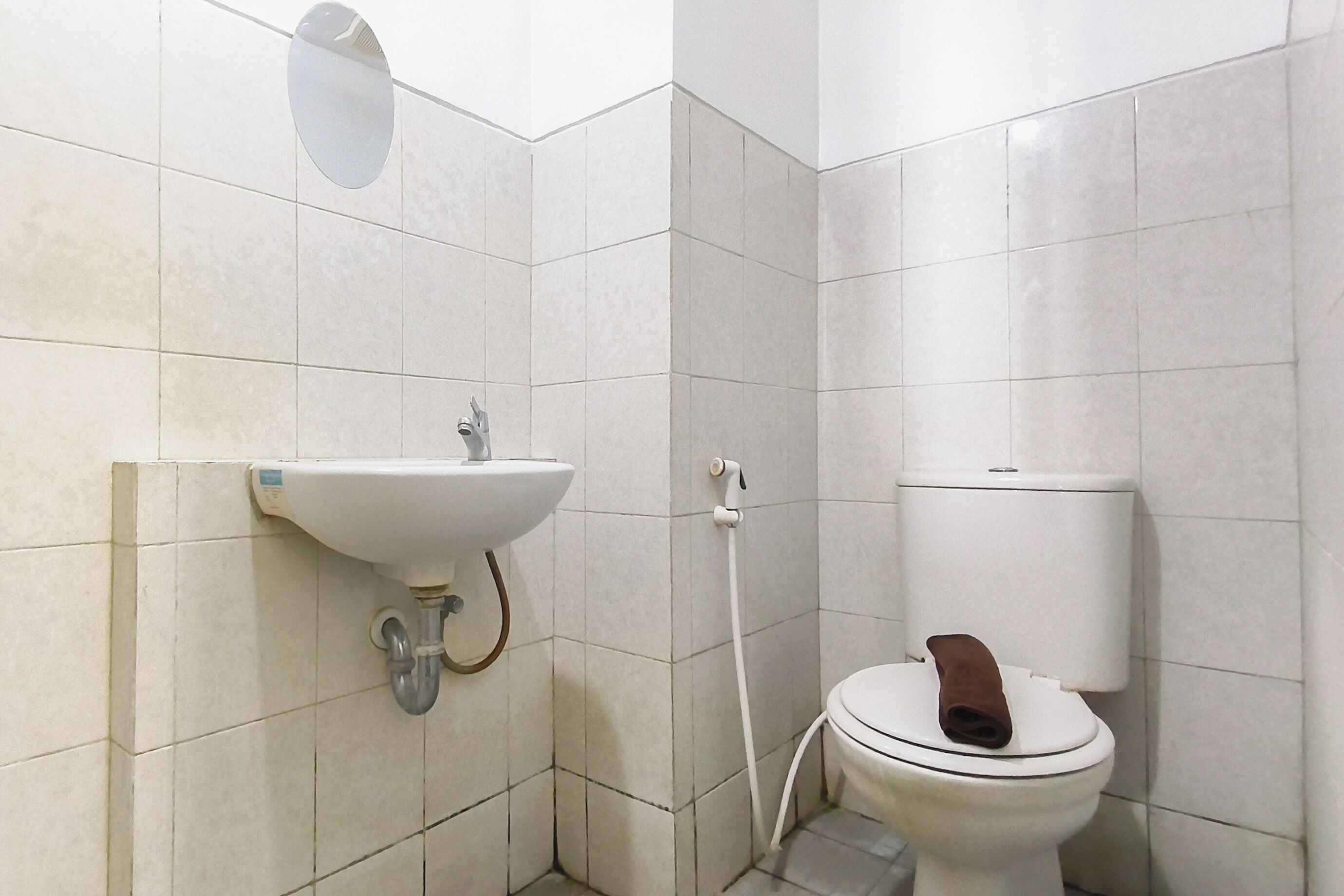 A bathroom with a sink, toilet, and a shower head.