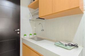 Een keuken met een spoelbak, kastjes en een aanrecht.