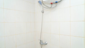 A shower with a handheld showerhead and a wall-mounted control panel. - Neat Studio At Amethyst Apartment Near Jiexpo (Jakarta)