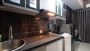 Een moderne keuken met een RVS spoelbak, een gasfornuis en een inbouwoven.