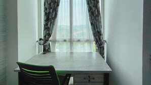 A room with a dining table and chairs, a window with sheer curtains, and a view of the outside. - Comfortable Gray Studio Room At Apartment Taman Melati Jatinangor (Hegarmanah)
