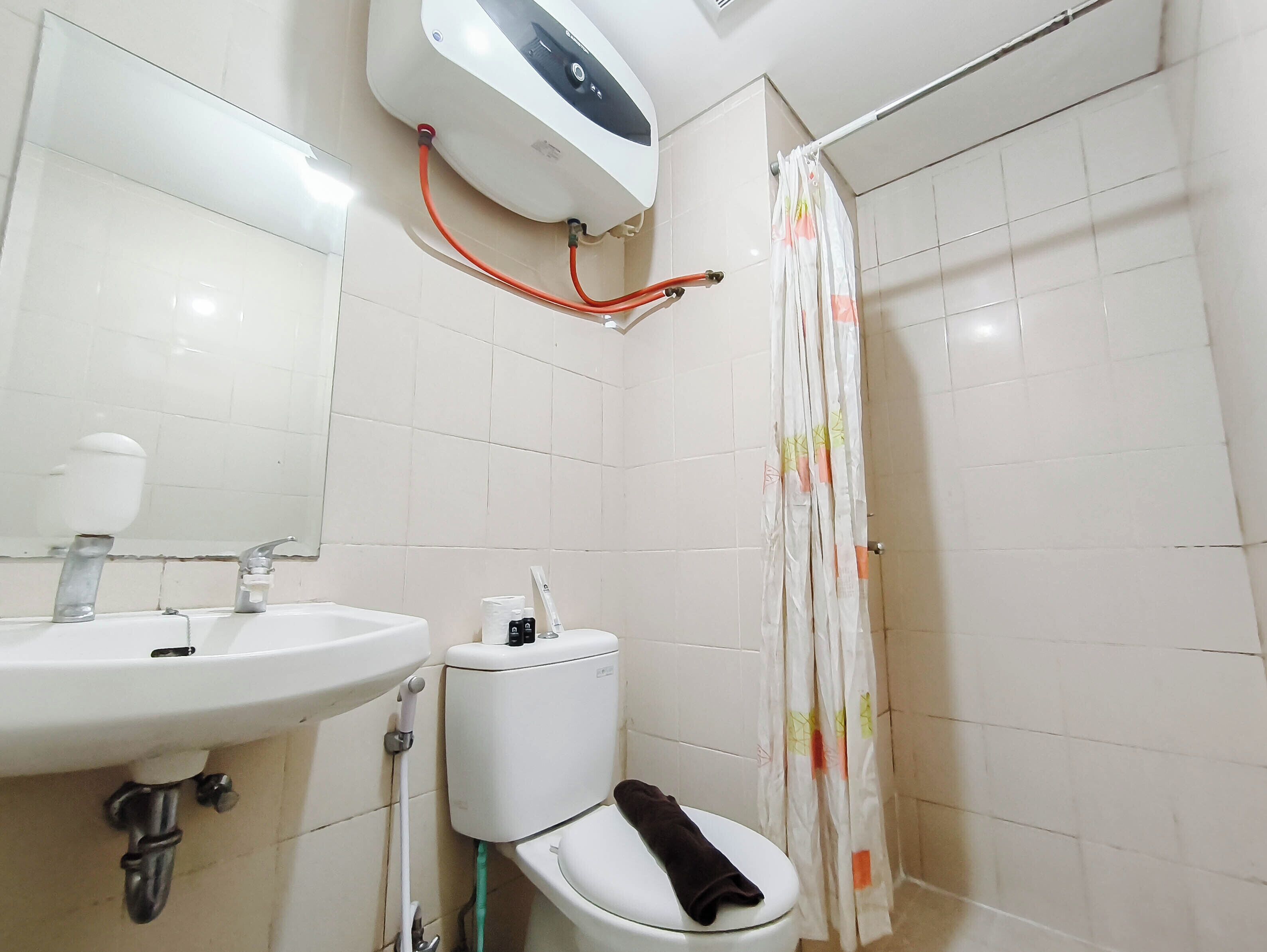 A bathroom with a white sink, toilet, and shower curtain.
