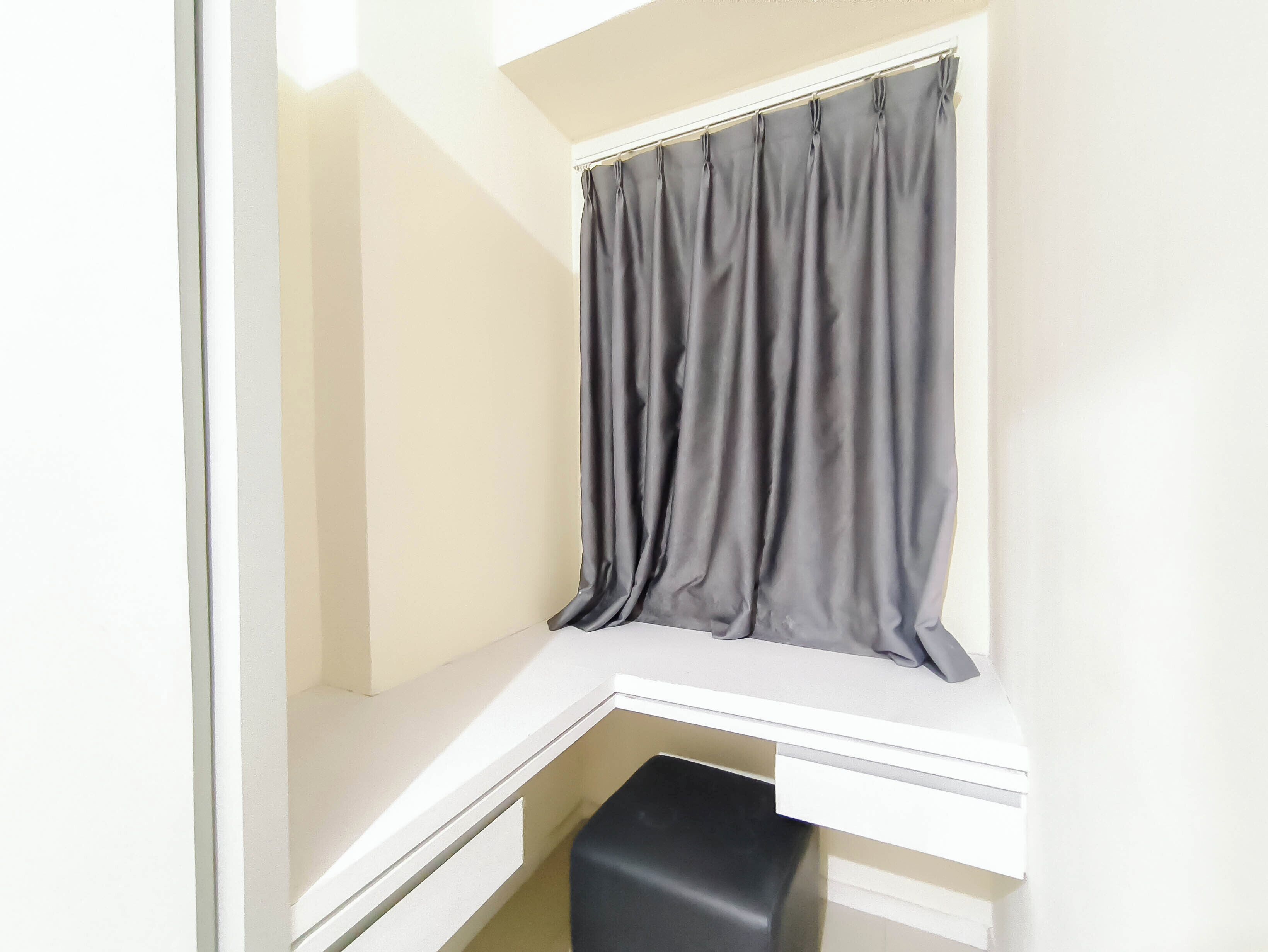 A corner closet with a window, a white countertop, and a black storage box.