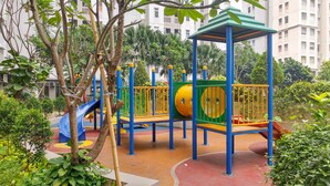 Ein Spielplatz mit Rutsche, Klettergerüsten und einem überdachten Spielbereich.