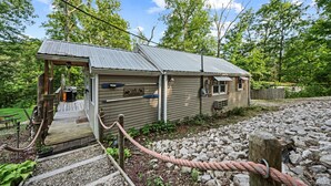 A rustic cabin with a wooden deck, a metal roof, and a stone pathway leading to the entrance. - Cozy 1-bedroom cabin in perfect Hudson with cool AC (Hudson)