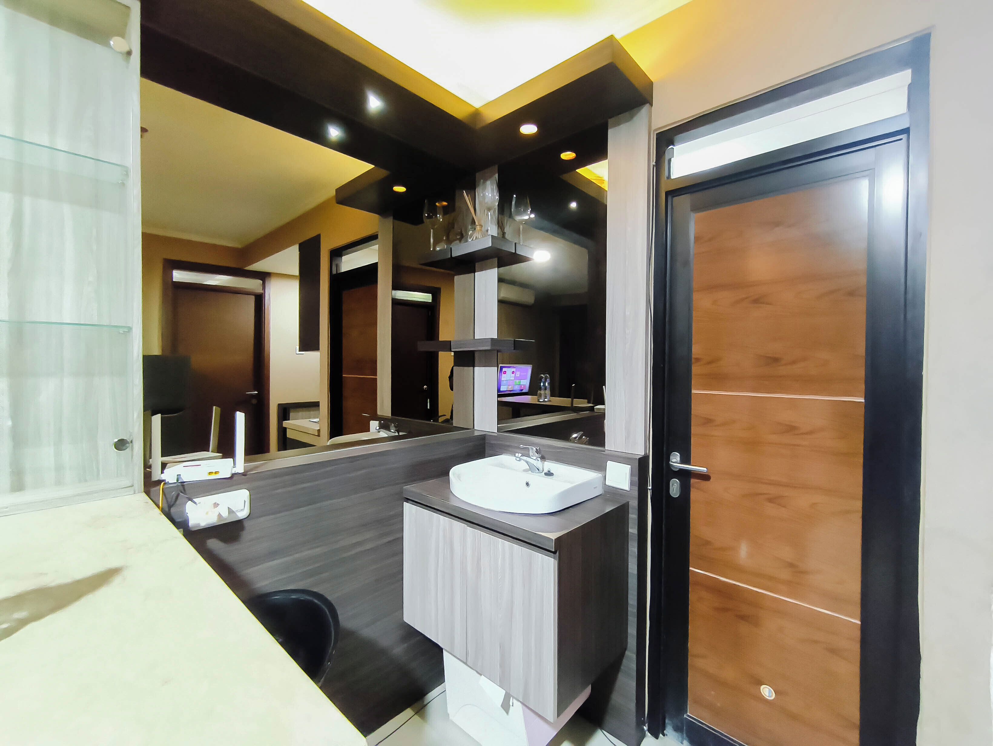 A modern bathroom with a large mirror, a sink, and a shower area.