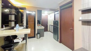 A modern kitchen with a countertop, sink, and refrigerator. - 4 Pax Warm Brown 2Br At Gateway Pasteur Apartment (Cimahi)