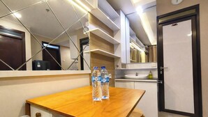 Une cuisine moderne avec une table en bois, deux bouteilles d’eau, un évier et un réfrigérateur.