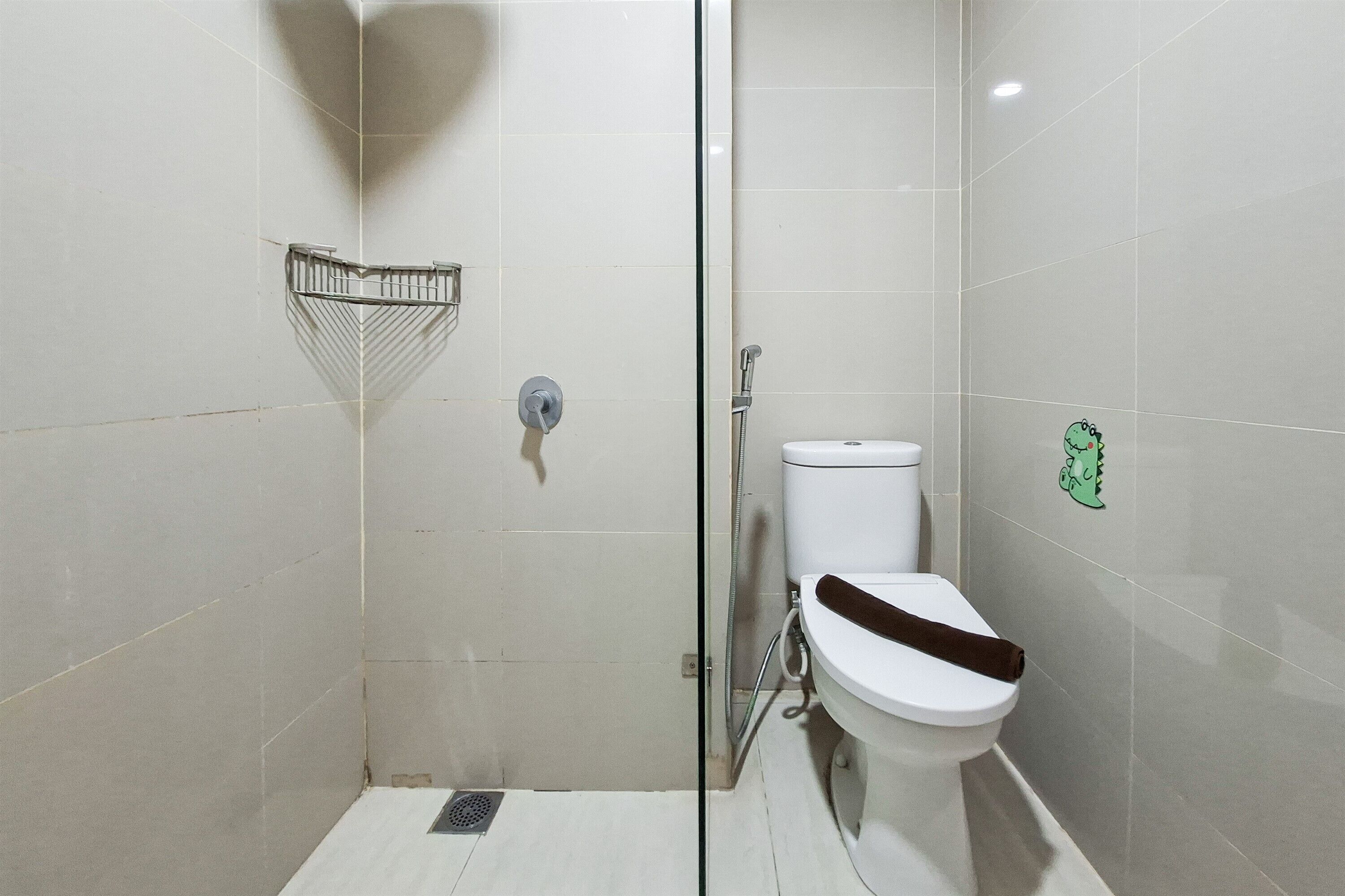 A bathroom with a shower, toilet, and a towel rack.