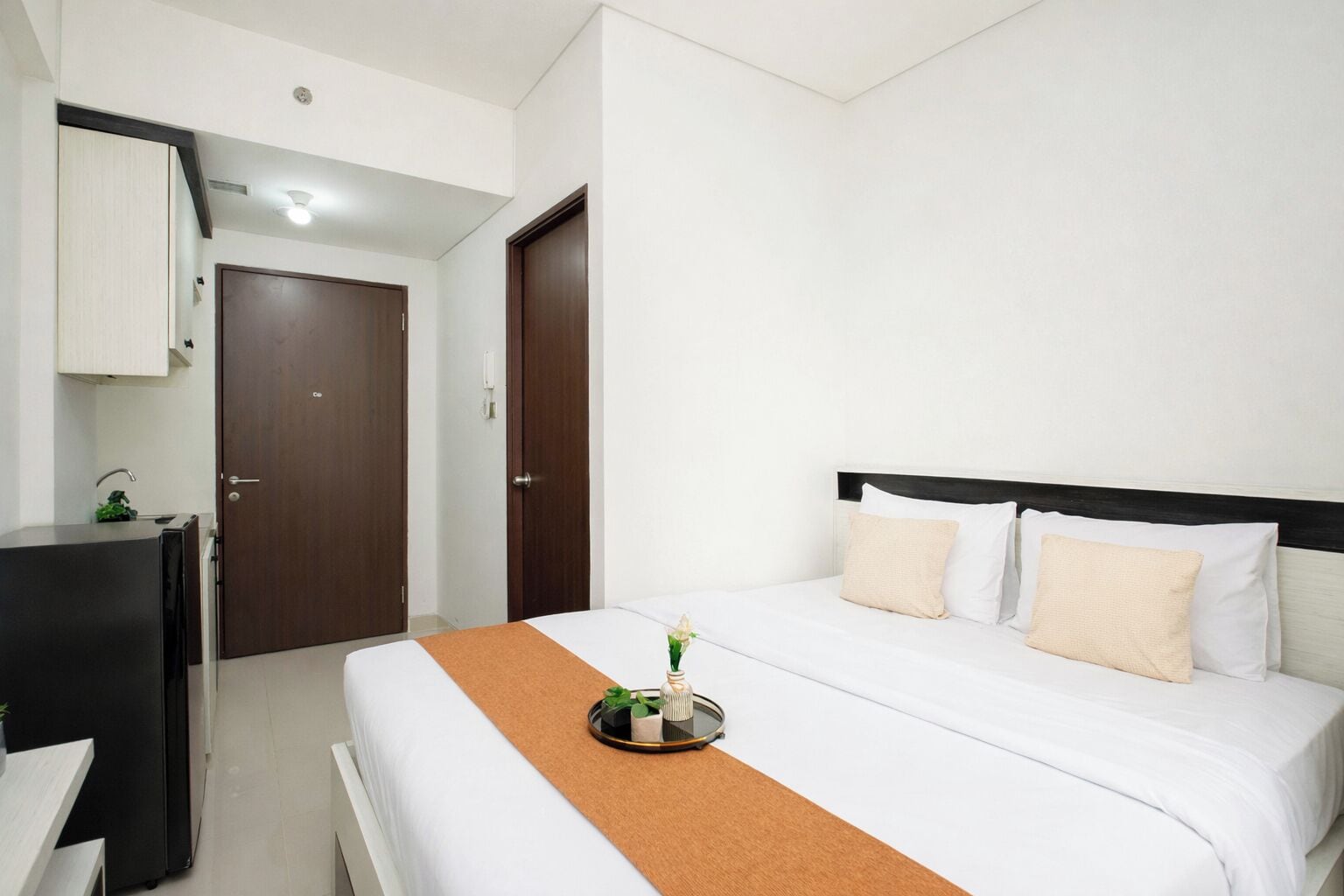 A hotel room with a bed, a desk, and a wardrobe.