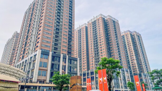 Um edifício residencial alto, com várias sacadas e um design arquitetônico moderno.