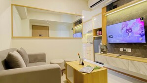 A modern living room with a sofa, a coffee table, a TV, and a large mirror.