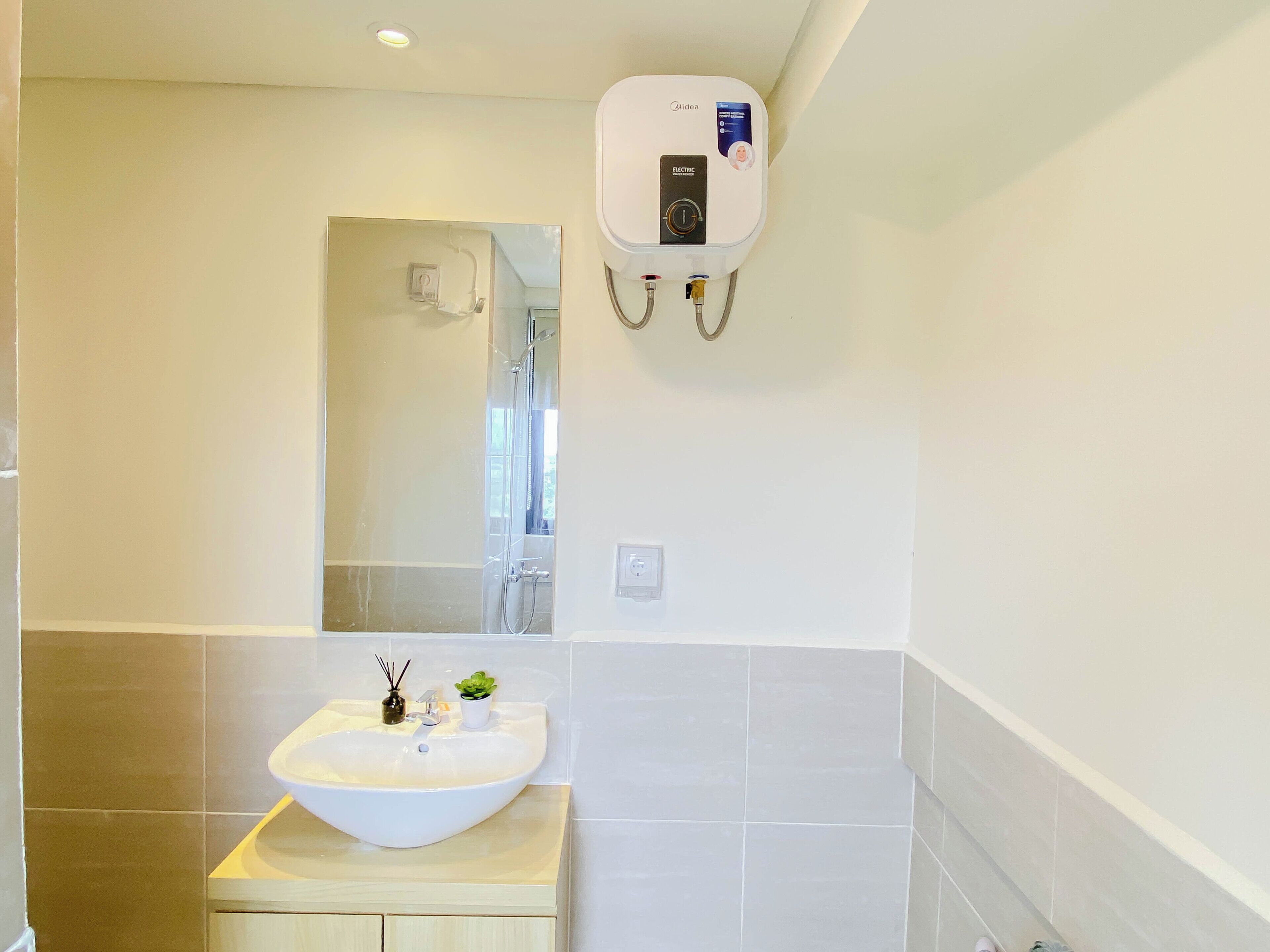 A bathroom with a white sink, a mirror, and a wall-mounted electric heater.