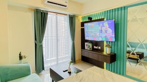 Habitación de hotel con televisión, aire acondicionado, sofá, mesa y vistas de edificios altos.