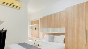 Una habitación de hotel moderna con cama, mesita de noche y armario.