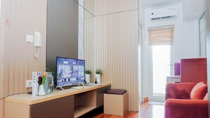 Een moderne kamer met een houten bureau, een computer, een rode stoel en een raam met jaloezieën.