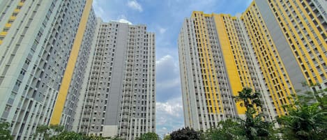 A high-rise residential building with a swimming pool in the foreground.