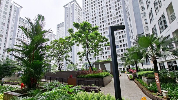 A residential area with high-rise buildings, greenery, and a pathway. - Simple 2Br Space At Apartment M-Town Residence (Gading Serpong)